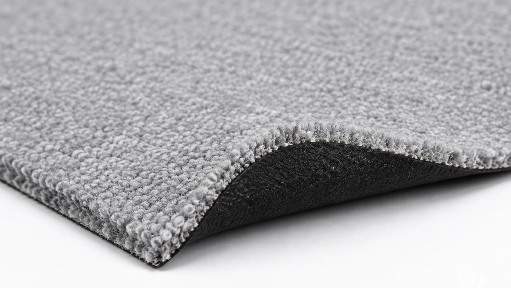 Close-up reference view of low-pile light grey exhibition carpet with black latex backing